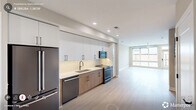 Located at 1001 Hammell Dr in Raleigh, NC, this contemporary two-story residence offers 2 bedrooms and 3 bathrooms across two well-appointed floors. The main level features an open-concept kitchen and living area bathed in natural light from large floor-to-ceiling windows. The kitchen is outfitted with sleek white upper cabinetry, warm wood-toned lower cabinets, white quartz countertops, and a full suite of modern stainless appliances including a French door refrigerator, dishwasher, gas range, and built-in microwave. Light hardwood flooring flows throughout, complementing the clean, neutral palette. A striking staircase with dark metal railings connects the two floors, adding a modern architectural accent to the living space. Upstairs, the generously sized primary bedroom enjoys sweeping city views through expansive windows and includes a well-organized walk-in closet with built-in shelving and hanging rods. The three bathrooms are finished with warm wood vanities, illuminated mirrors, white countertops, and matte black fixtures — one featuring a soaking tub and shower combo. Additional closets throughout provide ample storage. Ceiling fans in the bedrooms and living area enhance comfort, while recessed lighting adds a polished touch throughout this thoughtfully designed Raleigh home.