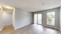 Located at 4610 N Armenia Ave in Tampa, FL, this 2-bedroom, 1-bathroom unit offers a well-organized single-floor layout designed for comfortable everyday living. The open living room is finished with durable wood-style flooring and soft gray walls, and is bathed in natural light through a sliding glass door with vertical blinds that provides direct outdoor access. An additional window further brightens the space with views of surrounding greenery.

The kitchen connects to the living area via a convenient pass-through window, creating an open, communicative layout. It features stainless steel appliances, including a range and refrigerator, complemented by white upper cabinetry, gray lower cabinets, a gray subway tile backsplash, and light stone-style countertops.

A central hallway leads to both bedrooms and the shared bathroom. The primary bedroom is generously sized, carpeted for comfort, and includes a ceiling fan, a window with outdoor views, and a large sliding-door closet. The second bedroom is similarly carpeted and features a closet and window. The bathroom is clean and functional, with a white vanity, mirror, and wood-style flooring. A textured ceiling runs throughout the unit, adding a consistent architectural detail to the overall design.