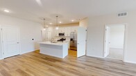 Located at 29154 Stony Hill Drive in Perrysburg, Ohio, this well-appointed 2-bedroom, 2-bathroom single-story home offers a clean, modern aesthetic with thoughtful design throughout. The open-concept living and kitchen area serves as the heart of the home, featuring warm luxury vinyl plank flooring, a ceiling fan, and a seamless flow between spaces. The kitchen is a standout, equipped with white shaker cabinetry extending to the ceiling, quartz countertops, a classic subway tile backsplash, stainless steel appliances including a gas range, built-in microwave, and French door refrigerator, plus a central island with pendant lighting — ideal for both meal prep and casual dining. The spacious primary bedroom offers generous proportions with a dedicated closet and direct access to a well-designed en-suite bathroom, which features a white vanity with ample cabinetry and wood-look flooring. The second bedroom is carpeted and benefits from natural light through a window with blinds. A second full bathroom mirrors the clean, white aesthetic of the primary bath. Additional highlights include a dedicated laundry room with shelving and hookups, a separate closet for storage, and a consistent neutral color palette that makes the entire home feel bright, airy, and move-in ready.