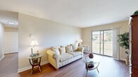 Located at 1068 Todd Farm Dr in Elgin, Illinois, this well-appointed 2-bedroom, 2-bathroom residence offers a thoughtfully designed single-level layout. The living room serves as the heart of the home, featuring warm hardwood-style flooring, neutral walls, and a large sliding glass door that floods the space with natural light and provides views of the surrounding greenery. The dining area is conveniently positioned adjacent to the kitchen and living space, creating a seamless open flow ideal for everyday living and entertaining. The galley-style kitchen is well-equipped, featuring rich wood cabinetry, light countertops, a double sink, and black appliances including a range, refrigerator, and built-in microwave. The primary bedroom offers comfortable carpeting, a natural light-filled window with outdoor views, and a dedicated closet for ample storage. The second bedroom is equally well-sized with plush carpeting. Both bathrooms are functional and clean, with one featuring warm wood vanity cabinetry and hardwood-style flooring. The residence also includes a dedicated laundry area and two closets for additional storage. The overall ambiance is warm and inviting, with a cohesive neutral palette throughout.
