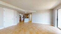 Located at 360 W Palmetto Park Rd in Boca Raton, Florida, this single-floor residence offers a well-designed open-concept layout that seamlessly connects the living, dining, and kitchen areas. Warm-toned large-format ceramic tile flooring flows throughout the main living spaces, complemented by neutral walls and recessed lighting that enhance the bright, airy atmosphere.

The kitchen is a functional centerpiece, featuring white shaker-style cabinetry with black hardware, a classic white subway tile backsplash, stainless steel appliances including a refrigerator, electric range, and over-the-range microwave, and a curved peninsula with a white countertop and undermount sink — ideal for both meal preparation and casual dining.

The spacious living area opens directly to a private balcony through sliding glass doors, allowing abundant natural light and outdoor views to fill the room. A ceiling fan adds comfort to this generous space.

The bedroom areas feature durable wood-look flooring, offering a warm contrast to the tiled common areas. The primary bathroom is well-appointed with a soaking tub, a glass-enclosed walk-in shower, and tile surround, while a second bathroom provides a glass-enclosed shower, vanity, and tile flooring. Additional storage is accessible via a louvered closet. The space combines practical design with comfortable Florida living.