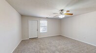 This single-floor, handicap-accessible home in Munford, Tennessee offers a functional and comfortable layout with two bedrooms and two bathrooms. The spacious living room greets you at the entrance, featuring plush carpeting, a ceiling fan with light fixture, and a window that lets in natural light, creating a bright and airy atmosphere. The kitchen is well-equipped with warm oak cabinetry, laminate countertops, white appliances including a refrigerator, electric range, and built-in microwave, all complemented by durable hardwood-style flooring. A convenient breakfast bar separates the kitchen from the adjoining living area, ideal for casual dining. Both bedrooms are carpeted and generously sized, each served by ceiling fans. The primary bedroom features direct access to a dedicated bathroom and a closet, while the second bedroom is bright with a window view. The two bathrooms include a full bath with a tub and shower surround, and a half bath with a single vanity sink and hardwood-style flooring. Neutral tones throughout the home create a clean, move-in ready aesthetic, and the accessible design ensures ease of living for all occupants.