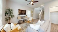 This two-story home offers a thoughtfully designed layout spread across two floors, with the main level featuring an open-concept living, dining, and kitchen area. The bright living room is anchored by light hardwood-style flooring, a ceiling fan, and large windows that fill the space with natural light. A staircase leads to the upper level, adding to the home's airy, connected feel.

The kitchen is a standout, featuring crisp white cabinetry, a subway tile backsplash, stainless steel appliances, pendant lighting over a central island with a quartz countertop, and access to a dedicated pantry. The adjacent dining area comfortably accommodates a full dining table and benefits from window views and recessed lighting.

Upstairs, the spacious primary bedroom features plush carpet, a ceiling fan, natural light, and a well-appointed en-suite bathroom with a quartz vanity and a tiled walk-in shower. Two additional bedrooms are carpeted and include windows with exterior views. The home includes four full bathrooms in total, two closets, and in-unit laundry with a full-size washer and dryer. Throughout, the home maintains a clean, modern aesthetic with neutral tones, white panel doors, and consistent finishes.