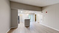 Located at 765 Polk Drive in Arlington, TX, this two-bedroom, two-bathroom residence offers a well-designed single-floor layout with a cohesive neutral color palette throughout. The open-concept kitchen is a standout feature, boasting white shaker cabinetry, a subway tile backsplash, light stone countertops, stainless steel appliances, pendant lighting, and a skylight that fills the space with natural light. A breakfast bar connects the kitchen to the main living and dining areas, creating an inviting flow. The living room is highlighted by light wood-style flooring and a classic fireplace with a white mantel, providing a warm focal point. Both bedrooms are carpeted for comfort — the primary bedroom offers a well-sized layout, while the secondary bedroom features a built-in window seat with views of greenery and a sliding closet. Both bathrooms are equipped with tub-shower combinations finished in neutral tile surrounds. Throughout the residence, warm gray walls, white trim, and consistent flooring choices create a clean, unified aesthetic. Sliding glass doors in the living area allow for natural light and outdoor access, enhancing the overall sense of openness in this thoughtfully laid-out Arlington home.