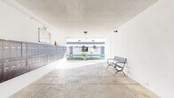 Located at 4444 Hazeltine Ave in Sherman Oaks, Los Angeles, this expansive residential community spans a generous footprint across a single level of shared amenity spaces. The entrance greets residents with a covered walkway, a row of individual mailboxes, and a bench seating area, opening directly onto the bright, sunlit courtyard beyond.

The outdoor areas are a true highlight of the property. Multiple landscaped courtyards feature gravel pathways lined with stepping stones, mature palm trees, lush shrubs, and decorative planters. Outdoor barbecue grills and shaded dining areas with umbrella-covered tables provide inviting spaces for gathering, while a gated swimming pool with lounge chairs offers a resort-like retreat. The crisp white exterior of the building, accented with navy blue doors and iron railings, lends a clean, modern aesthetic throughout.

The fitness center is well-appointed with light hardwood flooring, recessed lighting, floor-to-ceiling mirrors, and a comprehensive selection of equipment including treadmills, ellipticals, free weights, resistance tools, and exercise mats — complemented by a mounted TV for entertainment during workouts.

The laundry facility is neatly organized with stacked washer and dryer units, warm hardwood-style flooring, built-in storage cabinetry, and a folding counter, making it both functional and comfortable for everyday use.