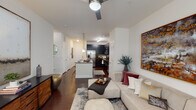 Located on Fourth Alley in Durham, NC, this single-floor residence offers a thoughtfully designed open-concept layout that seamlessly connects the kitchen, dining, and living areas. The kitchen is a standout feature, showcasing dark espresso cabinetry that extends to the ceiling for ample storage, granite countertops, a mosaic tile backsplash, and a full suite of stainless steel appliances including a range, microwave, dishwasher, and refrigerator with ice maker. A central island with pendant lighting provides additional prep and casual dining space. Rich hardwood-style flooring flows throughout the main living areas, anchoring the open and airy living room, which is equipped with a ceiling fan and connects effortlessly to the kitchen. The bedroom is carpeted for comfort, featuring windows with blinds and drapes that invite natural light and outdoor views. It is complemented by a walk-in closet with built-in shelving. The bathroom is clean and functional, with a dark vanity, tiled shower, and light wood-look flooring. Throughout the residence, a neutral color palette and modern finishes create a cohesive, contemporary ambiance well-suited for comfortable everyday living.