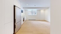 Located at 10 Rosemount in the prestigious Westmount neighbourhood of Quebec, this clean and modern 2-bedroom, 1-bathroom unit offers a thoughtfully designed single-floor layout with a bright, minimalist aesthetic. Light hardwood flooring runs consistently throughout the space, complementing the crisp white walls and creating a warm, cohesive feel.

The open-concept kitchen is a standout feature, outfitted with flat-panel white cabinetry extending to the ceiling, stainless steel appliances including a built-in oven, microwave, and refrigerator, a smooth cooktop, and white quartz countertops. A window brings in natural light and overlooks the surrounding streetscape.

The spacious primary bedroom offers a generous footprint with a sliding-door closet, a window with street views, and a baseboard heating unit. The second bedroom is similarly bright and clean, with its own window and access to the hallway. Both rooms maintain the consistent hardwood flooring and neutral palette found throughout the unit.

The bathroom is elegantly finished with large-format grey tiles, a wall-mounted white vanity with under-sink storage, a soaker tub, and a glass-enclosed shower with a rain-style fixture — offering a spa-like experience.

A connecting hallway ties all rooms together efficiently, completing this well-organized and modern urban residence.