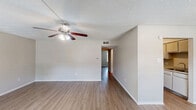Located at 5151 Highland Rd in Baton Rouge, Louisiana, this single-story, 2-bedroom, 2-bathroom unit offers a practical and comfortable layout throughout. Light-toned wood-look flooring runs consistently across all rooms, lending a clean and cohesive feel to the space.

The living room serves as the heart of the home, featuring a ceiling fan with light fixture, two windows that invite natural light, and direct access to the front entry. The galley-style kitchen is efficiently designed with white cabinetry, speckled countertops, and black appliances including a refrigerator and range, complemented by ample upper and lower cabinet storage.

Both bedrooms are well-proportioned, with the primary bedroom offering generous closet space via double sliding and louvered bi-fold closet doors, along with a private en-suite bathroom. The second bedroom includes a window with an outdoor view, providing natural light and ventilation. Textured ceilings are present throughout the unit.

Each bathroom is equipped with a full tub and shower combo featuring brushed nickel fixtures and safety grab bars in one bathroom, a vanity with speckled countertop, and hardwood-style flooring. A hallway connects the bedrooms and bathrooms, completing this efficiently organized floor plan.