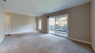 Located at 810 Polhemus Rd in San Mateo, CA, this well-appointed one-bedroom, one-bathroom unit offers a thoughtfully organized single-level layout. The combined kitchen and living area forms the heart of the home, where the living room features warm neutral tones, plush carpet flooring, and a ceiling fan. Sliding glass doors open directly onto a private balcony, inviting an abundance of natural light and offering pleasant views of mature surrounding trees. An additional window further brightens the space.

The galley-style kitchen is efficiently designed with gray cabinetry lining both sides, light countertops, a stainless steel refrigerator, and a black electric range with overhead ventilation. Wood-look flooring runs through the kitchen, adding warmth and easy maintenance to a functional cooking space.

The spacious bedroom is carpeted and filled with natural light from a large window overlooking greenery. A double sliding-door closet provides ample storage. A connecting hallway links the main living areas to the full bathroom, which features wood-look flooring, a white tub-shower combination, a vanity, and a window that allows natural light. The unit's clean, neutral palette and practical layout make it a comfortable and versatile living space.