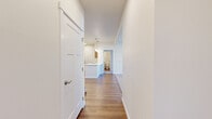 Located in Spokane, WA, this thoughtfully designed 4-bedroom, 2-bathroom unit offers a functional single-floor layout with a clean, modern aesthetic throughout. The interior opens through a bright hallway finished with warm hardwood-style flooring that extends through the main living areas. The kitchen features light wood cabinetry, stainless steel appliances including a refrigerator and range, ample counter space, and pendant lighting — offering an efficient and stylish workspace. The living room is carpeted and filled with natural light through large windows and a glass-paneled entry door, providing a welcoming and open atmosphere with views of the surrounding neighborhood. Each of the four bedrooms is carpeted for comfort, with neutral-toned walls and natural light from windows. The bedrooms are equipped with sliding double-panel closets, providing practical storage. Both bathrooms are finished with hardwood-style flooring, tub-shower combinations, and wood-toned vanities with generous mirror and counter space. A dedicated in-unit laundry area houses a full-size washer and dryer, adding everyday convenience. The unit's consistent use of light tones, clean lines, and quality finishes throughout creates a bright, cohesive living environment.