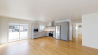 Located in Hollywood's vibrant Tamarind Avenue corridor, this thoughtfully designed 2-bedroom, 2-bathroom residence offers a clean, modern aesthetic throughout. Warm light-toned hardwood flooring runs continuously across the entire single-level floor plan, creating a cohesive and airy feel.

The open-concept kitchen and living area serves as the heart of the home. The kitchen is outfitted with flat-front gray cabinetry, white subway tile backsplash, stainless steel appliances including a gas range with overhead hood and a full-size refrigerator, and a built-in microwave. A window above the sink brings in natural light, while recessed lighting completes the functional yet stylish space. The adjacent living area features a large sliding glass door that opens directly onto a private balcony, filling the room with natural light.

Both bedrooms are bright and well-proportioned, with large windows, individual wall-mounted AC units, and clean white walls. The primary bedroom includes a mirrored sliding closet. Three closets in total provide ample storage throughout.

The two bathrooms echo the home's modern design language, featuring floating white vanities with undermount sinks, rounded mirrors with sleek sconce lighting, and one full bath with a soaking tub framed by vertically stacked white tile. An in-unit laundry area adds everyday convenience to this refined Hollywood residence.