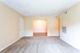 Located at 3300 N Ingle Pl in Macon, Georgia, this single-floor unit offers a straightforward and functional layout suited for comfortable everyday living. The spacious living room is carpeted and features warm, neutral-toned walls, a textured ceiling, and a sliding glass door fitted with vertical blinds that allows natural light to pour in while providing access to the outdoors. A second interior view of the living area reveals a thermostat, ventilation fixtures, and an additional access point to the rest of the unit.

The kitchen is equipped with warm wood-toned cabinetry, granite-style countertops, a black electric range, a dishwasher, and tile flooring — offering a practical cooking and prep space. The bathroom is cleanly finished with tile flooring in a wood-look pattern, a toilet, a towel bar, and a tub-shower combination with built-in shelving.

Multiple bedrooms are carpeted and painted in soft, warm tones, each featuring windows with blinds that bring in natural light and views of the surrounding area. The textured ceilings and clean white baseboards are consistent throughout, lending a cohesive look to the entire unit. The floor plan, visible through the dollhouse view, shows a well-organized, single-level layout with clearly defined living, sleeping, and utility zones.
