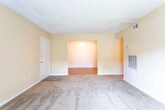 Located at 3300 N Ingle Pl in Macon, Georgia, this single-floor unit offers a straightforward and functional layout suited for comfortable everyday living. The spacious living room is carpeted and features warm, neutral-toned walls, a textured ceiling, and a sliding glass door fitted with vertical blinds that allows natural light to pour in while providing access to the outdoors. A second interior view of the living area reveals a thermostat, ventilation fixtures, and an additional access point to the rest of the unit.

The kitchen is equipped with warm wood-toned cabinetry, granite-style countertops, a black electric range, a dishwasher, and tile flooring — offering a practical cooking and prep space. The bathroom is cleanly finished with tile flooring in a wood-look pattern, a toilet, a towel bar, and a tub-shower combination with built-in shelving.

Multiple bedrooms are carpeted and painted in soft, warm tones, each featuring windows with blinds that bring in natural light and views of the surrounding area. The textured ceilings and clean white baseboards are consistent throughout, lending a cohesive look to the entire unit. The floor plan, visible through the dollhouse view, shows a well-organized, single-level layout with clearly defined living, sleeping, and utility zones.