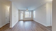 Located at 12509 Crown Park Ct in Charlotte, NC, this single-floor residence offers a thoughtfully designed open-concept layout that seamlessly connects the living, dining, and kitchen areas. The main living space features warm hardwood-style flooring, a ceiling fan, and large windows with blinds that invite generous natural light while offering views of the surrounding community. A welcoming entry leads directly into this bright, airy common area.

The kitchen is a standout feature, showcasing rich dark cabinetry, granite countertops, a classic white subway tile backsplash, and a full suite of stainless steel appliances including a refrigerator, range, and built-in microwave. A peninsula with a granite overhang provides additional workspace and casual seating, while pendant and track lighting enhance the overall ambiance.

The bedrooms are finished with plush carpeting and ceiling fans, offering a comfortable retreat. Each room benefits from natural light through windows with blinds. Two full bathrooms serve the unit, both consistent in style with dark wood vanities, granite countertops, and tub-shower combinations. The hardwood-style flooring extends through the bathrooms, tying the design together cohesively throughout this well-appointed Charlotte residence.