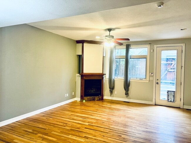 Sala de estar con chimenea a gas y salida a un patio trasero. - 2317 Decatur St