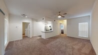 This two-story residence is thoughtfully designed with a bright, open layout that promotes a comfortable and functional living environment. The main level centers around a generously sized living area finished with plush wall-to-wall carpeting and a ceiling fan overhead. A peninsula-style kitchen is seamlessly integrated into the space, featuring stainless steel appliances including a range, microwave, and refrigerator, complemented by two-tone gray and white cabinetry, granite countertops, a undermount sink, and dark hardwood-style flooring. Track lighting illuminates the kitchen area effectively.

The bedrooms are carpeted and each equipped with ceiling fans. Natural light enters through blinded windows, and one room features sliding door access. The bathrooms are finished consistently with gray vanity cabinetry, granite countertops, dark hardwood-style flooring, and tub-shower combinations with chrome fixtures. A window in one bathroom adds natural ventilation.

An attached garage with an automatic opener provides secure parking and additional storage potential. Overall, the space presents a clean, neutral palette throughout, creating a versatile and move-in ready environment.