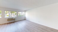 Located at 3700 10th Avenue in San Diego's desirable Mission Hills neighborhood, this one-bedroom, one-bathroom unit offers a thoughtfully designed layout with modern finishes throughout. Light wood-tone flooring runs throughout the space, complementing the crisp white walls and creating a clean, contemporary aesthetic.

The open living area is bathed in natural light, courtesy of large sliding windows that frame views of a landscaped pool area below — a standout feature that brings a resort-like ambiance to everyday living. A wall-mounted HVAC unit provides climate control directly within the main living space.

The kitchen is well-appointed with two-toned cabinetry — rich wood lower cabinets paired with white upper cabinets — complemented by a white subway tile backsplash, a stainless steel dishwasher, and ample counter space. Recessed lighting keeps the kitchen bright and functional.

The spacious primary bedroom features frosted glass sliding closet doors, offering both storage and a sleek, modern look. Two closets provide generous storage throughout the unit. The bathroom includes a walk-in shower with glass enclosure and vanity with cabinetry.

Compact yet efficient, this unit makes excellent use of its footprint, delivering a bright, modern living experience in a prime San Diego location.