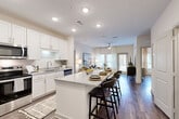 Located at 700 Avett Ln in Charlotte, NC, this 2-bedroom, 2-bathroom residence offers a thoughtfully designed single-level floor plan that maximizes functionality and comfort. The open-concept kitchen and living area serves as the heart of the home, where crisp white shaker cabinetry, granite countertops, subway tile backsplash, and stainless steel appliances combine for a clean, modern aesthetic. A large kitchen island with bar seating provides additional dining and prep space, flowing seamlessly into the living room. The living area is bright and welcoming, featuring hardwood-style flooring, a ceiling fan, and large windows with access to an outdoor area, filling the space with natural light. The primary bedroom is a serene retreat, offering generous proportions, large windows, a ceiling fan, and a dedicated walk-in closet with wire shelving. The en-suite bathroom features a dual-sink vanity with granite countertops and white cabinetry. The second bedroom is equally comfortable, also benefiting from natural light and closet space. The second full bathroom mirrors the same refined finishes, with a granite-topped vanity and a shower. Hardwood-style flooring runs consistently throughout, tying the entire residence together with a cohesive, contemporary feel.