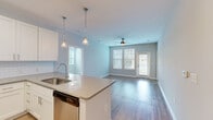 Located at 201 Sawyer Circle in Charleston, SC, this well-designed 2-bedroom, 2-bathroom single-story home offers a clean, modern aesthetic with a thoughtful open-concept layout. Light-toned wood-look flooring flows throughout the main living areas, complementing the soft neutral wall palette and recessed lighting.

The kitchen is a standout feature, showcasing white shaker-style cabinetry, a classic subway tile backsplash, sleek quartz countertops, and a full suite of stainless steel appliances including a French door refrigerator, electric range, and built-in microwave. A central island with pendant lighting and an integrated sink connects seamlessly to the living area, which is brightened by large windows and a glass-paned exterior door. A ceiling fan adds both comfort and function to the living space.

The primary bedroom offers a comfortable footprint with dual windows, a ceiling fan, and plush carpeting. It is served by a dedicated walk-in closet outfitted with wire shelving systems. The second bedroom also features carpet flooring, natural light, and its own walk-in closet with wire shelving. Both bathrooms are finished in clean, bright white, with one featuring a soaking tub and shower combination. The home's layout is practical and efficient, making excellent use of its well-proportioned floor plan.