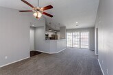 Located at 5100 Foxridge Dr in Mission, Kansas, this single-floor residence offers a well-designed open layout with a variety of functional and comfortable features throughout. The living area is a standout space, characterized by soaring vaulted ceilings and a ceiling fan that enhance the sense of openness. A built-in fireplace flanked by shelving anchors the room, while large sliding glass doors and windows allow generous natural light to fill the space. Plush carpeting runs throughout the living and bedroom areas, adding warmth underfoot. The kitchen is efficiently designed with white cabinetry, granite-style countertops, stainless steel appliances including a refrigerator, range, and over-the-range microwave, and durable hardwood-style flooring. A peninsula counter with pendant lighting connects the kitchen to the living area, creating a seamless flow. A pantry provides added storage convenience. The bedrooms are well-proportioned, each equipped with a ceiling fan, natural light from windows, and plush carpet. The primary bedroom includes access to a walk-in closet. The bathrooms feature granite-style vanity countertops, a tub-shower combination, and clean, neutral finishes throughout. The overall palette of soft grays and whites gives the home a clean, move-in-ready appearance.