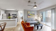 Located at 4659 Dawson Blvd in Atlanta, Georgia, this well-appointed single-story home offers a thoughtfully designed layout with a warm, modern aesthetic throughout. Light gray walls, light wood-tone flooring, and textured ceilings provide a cohesive backdrop across all rooms.

The living room serves as the heart of the home, featuring a ceiling fan with lighting, a wood-burning fireplace with a tiled surround, and a sliding glass door that opens to a private balcony. From the balcony, mature trees and lush Georgia woodland create a serene, natural backdrop. The adjacent dining area is defined by chair-rail molding and accommodates intimate gatherings comfortably.

The kitchen is well-equipped with gray cabinetry, white subway tile backsplash, light quartz countertops, a double-basin sink, and a full suite of stainless steel appliances including a range, microwave, refrigerator, and dishwasher. A skylight adds brightness to the space.

The bedroom is a peaceful retreat with ample natural light from a window with blinds and direct access to a generously sized walk-in closet outfitted with wire shelving on multiple walls. The bathroom features floor-to-ceiling gray tile in the tub-shower combination, a gray vanity with a white countertop, and wood-look flooring that continues the home's consistent design language.