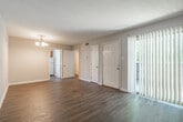 Located at The Pines in Jackson, Mississippi, this single-floor unit offers a practical and comfortable layout throughout. The living area is generously sized, featuring durable wood-look flooring, neutral-toned walls, and a chandelier light fixture that adds a classic touch. A vertical blind-covered sliding glass door floods the space with natural light and provides access to an outdoor patio area, enhancing the open feel of the room.

The kitchen is efficiently designed with warm oak cabinetry, dark countertops, and a double basin sink positioned beneath a window that brings in additional natural light. Appliances are included, and the layout maximizes counter and storage space for everyday use.

The bedrooms are carpeted for comfort, each equipped with a ceiling fan for year-round climate control. One bedroom features a large window with views of the surrounding greenery, while another includes built-in closet shelving, offering practical storage solutions. An additional room with wood-look flooring and subtle panel-style wall detailing provides flexibility as a bedroom or office space.

The bathroom includes a full tub-shower combo with classic white tile surround, a vanity with granite-style countertops, white cabinetry, and wood-look flooring, completing this well-appointed unit.