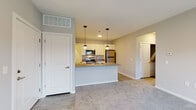 Located at 1001 Columbus Ave in Marysville, Ohio, this single-floor residence offers a thoughtfully designed open-concept layout. The kitchen serves as a central hub, equipped with stainless steel appliances including a refrigerator, electric range, and over-the-range microwave. Crisp white cabinetry pairs with neutral countertops, while a spacious peninsula with a double-basin sink and globe pendant lights above adds both function and style. Light wood-style flooring runs throughout the kitchen, transitioning seamlessly to plush carpeting in the living and bedroom areas. The living space is open and bright, connecting effortlessly to the kitchen and providing a comfortable, versatile layout. Bedrooms are carpeted and feature windows with blinds that allow for natural light. Two full bathrooms serve the unit — one featuring a tub-shower combination with tiled surround, and a second with a walk-in shower, both finished with wood-look flooring, vanities with grey countertops, and framed mirrors. A dedicated laundry area with stacked washer and dryer hookups adds everyday convenience. Neutral grey walls and clean white trim throughout give the space a modern, move-in-ready feel.