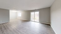 Located at 134 Graham Rd in Lansing, NY, this 2-bedroom, 1-bathroom unit offers a clean, modern layout across a single floor. Neutral gray walls and light-toned luxury vinyl plank flooring run throughout, creating a cohesive and contemporary aesthetic.

The living room is the standout space of the unit — generously proportioned and filled with natural light from multiple windows and a sliding glass door that opens to a private balcony with outdoor views. The open feel of this room provides ample flexibility for various furniture arrangements.

The primary bedroom is notably spacious, offering room for large furnishings, and includes a built-in closet with a hanging rod for convenient storage. The second bedroom is well-sized with its own closet and a window that brings in natural light. An additional room features built-in shelving, ideal for organized storage.

The bathroom is equipped with a full tub-and-shower combo featuring brushed nickel fixtures and a clean white surround. A hallway connects the main living areas to the bedrooms and bathroom, contributing to an efficient and functional floor plan. The unit presents a fresh, move-in-ready condition throughout.