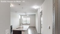 This 590-square-foot, one-bedroom, one-bathroom apartment, Unit 1651 at 650 S Main St in Fort Worth, TX, is designed for efficient, modern living across a single floor. The open-concept kitchen is a standout feature, showcasing dark espresso cabinetry, granite countertops, a kitchen island with a stainless steel sink, pendant lighting, and stainless steel appliances including a refrigerator, electric range, and microwave. Wood-style plank flooring runs throughout the kitchen and living areas, adding warmth and durability. The 120-square-foot bedroom is carpeted and includes a ceiling fan with a light fixture, neutral walls, and a large window with blinds that frames outdoor views of the surrounding area. The bathroom features dark cabinetry paired with granite countertops, a large vanity mirror, built-in shelving, wood-style flooring, and direct access to a walk-in closet. A hallway connects the main living spaces, maintaining a practical and cohesive layout. The unit's clean, neutral color palette and modern finishes throughout create a polished and functional living environment well-suited for urban residential life in Fort Worth.