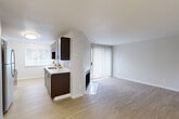 Located at 3520 NW Princeton Ln in Silverdale, Washington, this one-bedroom, one-bathroom unit offers a thoughtfully designed single-level layout. The open-concept living and kitchen area forms the heart of the space, centered around light wood-style flooring and a fireplace that anchors the living room. A sliding glass door floods the space with natural light and provides outdoor views framed by lush Pacific Northwest greenery.

The galley-style kitchen is well-appointed with rich dark-wood cabinetry, white countertops, stainless steel appliances including a refrigerator, electric range, and dishwasher, and a dual-basin sink. The kitchen opens seamlessly to the living area via a peninsula counter, creating an inclusive, connected feel.

The generously sized bedroom features plush carpet flooring, a window with natural light, and a baseboard heater. Two closets provide ample storage throughout the unit. The bathroom is clean and functional, featuring a full tub-shower combination with a curtain rod and wood-style flooring.

Additional conveniences include a dedicated laundry area and a neutral, bright color palette throughout that gives the space a fresh, move-in-ready character. The overall ambiance is clean, practical, and comfortable.