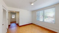 Located at 1100 E Washington Ave in East Point, GA, this one-bedroom, one-bathroom single-floor residence offers a practical and well-maintained layout. Consistent warm-toned terracotta tile flooring runs throughout the entire unit, complemented by white-painted walls and ceilings that keep the space feeling bright and clean.

The kitchen is a standout feature, equipped with stainless steel appliances including a range, over-the-range microwave, and dishwasher, paired with crisp white shaker-style cabinetry and a matte black faucet. Natural light enters through a window adjacent to the entry door, which also provides convenient exterior access.

The living room is a comfortable open area featuring a ceiling fan and a large window fitted with blinds, allowing for ample natural light and outdoor views. The bedroom, also outfitted with a ceiling fan, offers a generous footprint with closet access and natural light from a window. Two hallways connect the rooms efficiently, providing good flow throughout the unit.

The bathroom is cleanly finished with gray mosaic tile flooring, white subway tile surrounding the tub-shower combination, a white vanity with dark hardware, and a window for ventilation. The overall ambiance of the unit is functional, tidy, and well-lit.