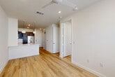 Located at 3112 Leeland St in Houston's 77003 zip code, this one-bedroom, one-bathroom unit offers a thoughtfully designed single-floor layout with modern finishes throughout. Light wood-tone flooring runs continuously across the space, complementing the crisp white walls and creating a clean, contemporary aesthetic.

The open-concept kitchen and living/dining area forms the heart of the unit. The kitchen is outfitted with dark espresso cabinetry extending to the ceiling for ample storage, a full suite of stainless steel appliances including a French door refrigerator, range, microwave, and dishwasher, and a white countertop peninsula with pendant lighting above — ideal for casual dining or entertaining.

The combined living and dining area is bright and functional, benefiting from natural light and a ceiling fan overhead. The bedroom is a comfortable, well-proportioned space with large windows that invite natural light and views of the surrounding greenery. Two closets, including a walk-in with built-in shelving and dual hanging rods, provide excellent storage capacity.

The bathroom features wood-look flooring, a sleek dark vanity with integrated storage, and a glass-enclosed walk-in shower with marble-style surround. Additional conveniences include a dedicated laundry area and utility room, completing this well-appointed, efficiently organized home.
