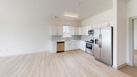 Located at 4407 E Main St in Richmond, VA, this single-floor unit presents a clean, modern aesthetic with a consistent design language carried throughout every room. Light wood-tone luxury vinyl plank flooring runs continuously across the living areas and bedrooms, creating a cohesive and airy feel underfoot.

The open kitchen is a functional highlight, outfitted with white shaker-style cabinetry extending to the ceiling for ample storage, a gray subway tile backsplash, light quartz countertops, and a full suite of stainless steel appliances including a French door refrigerator, electric range, over-the-range microwave, and dishwasher. A window above the sink brings in natural light.

The living and sleeping areas feature crisp white walls, ceiling fans with integrated lighting, and windows that frame outdoor views, allowing generous natural light to fill each room. Closet space is accessible directly from the bedroom areas.

The bathrooms are finished in a clean, minimal style with large-format tile flooring, white tub-shower combinations fitted with brushed nickel fixtures, and modern vanities with light stone-style countertops. The overall ambiance of the unit is bright, neutral, and move-in ready, suited to a contemporary lifestyle.