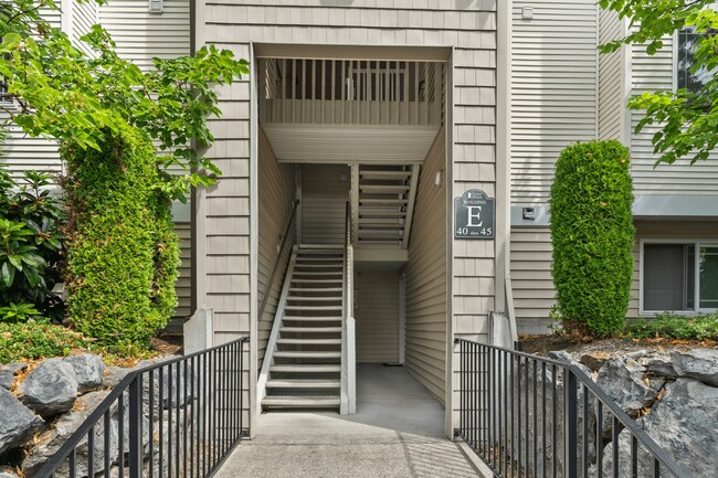 Cómodo acceso por escalera al Edificio E con un entorno bien mantenido. - Garden Villa Apartments