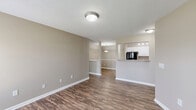 Located at 7111 Vedder Pl in Indianapolis, IN, this single-floor, 2-bedroom, 1-bathroom residence offers a practical and well-designed layout. The open living and dining areas are finished with rich, dark hardwood-style flooring and neutral warm-gray walls, creating a cohesive and inviting atmosphere throughout. Large windows and a glass-paneled entry door allow natural light to fill the living space, enhancing the clean, airy feel of the interior. Textured ceilings with flush-mount light fixtures provide consistent, even lighting throughout the common areas. The kitchen features white cabinetry, granite-look countertops, black appliances including a refrigerator, electric range, microwave, and dishwasher, along with track lighting and hardwood-style flooring that flows seamlessly from the main living areas. A pass-through counter connects the kitchen to the dining and living spaces, supporting an open-concept feel. Both bedrooms are carpeted and sized comfortably, with the primary bedroom offering access to a dedicated walk-in closet. Additional closets throughout the home provide ample storage. The full bathroom includes hardwood-style flooring and classic white finishes. A dedicated laundry area adds everyday convenience, rounding out this well-appointed residence.