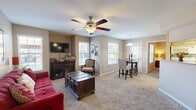This thoughtfully designed 2-bedroom, 2-bathroom single-floor home offers a comfortable and functional layout across a well-utilized footprint. The open-concept main living area seamlessly integrates the living room, dining room, and kitchen, creating a cohesive and inviting space. The living room features plush carpeting, a ceiling fan, and multiple windows that allow natural light to fill the room. The galley-style kitchen is equipped with granite countertops, light wood cabinetry, a double sink, and white appliances, with direct access to a dedicated in-unit laundry room. The dining area sits adjacent to the kitchen, accented by a pendant light fixture.

Both bedrooms are carpeted and include ceiling fans. The primary bedroom offers a comfortable sense of space, a window with natural light, and access to a walk-in closet outfitted with wire shelving. The second bedroom also includes closet storage. Each of the two full bathrooms features a tiled shower-tub combination with a distinctive diamond-pattern tile accent, granite-topped vanities with light wood cabinetry, and wood-look flooring. A connecting hallway ties the rooms together efficiently. The warm, neutral color palette throughout lends the home a cohesive and welcoming ambiance.