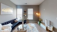 This single-floor residence presents a well-designed layout that balances contemporary style with practical functionality throughout each space. The kitchen serves as a central highlight, featuring dark espresso-toned cabinetry with sleek hardware, crisp white quartz countertops, a classic subway tile backsplash, and a full suite of stainless steel appliances. A built-in wine rack adds a distinctive touch, while a peninsula with bar seating creates a seamless transition into the living area. Wood-look flooring runs throughout the main spaces, contributing to a cohesive and modern aesthetic.

The living room is naturally lit by multiple windows fitted with horizontal blinds, set against neutral gray walls that create a calm, inviting atmosphere. A dedicated home office features carpeted flooring, a window for natural light, and ample wall space. The bedrooms are comfortably scaled with carpeted floors and windows providing natural light.

Both bathrooms are finished with dark wood vanities, white quartz countertops, and tub-shower combinations. One bathroom includes open shelving for additional storage. The walk-in closet is outfitted with an extensive wire shelving system, offering well-organized storage capacity throughout.