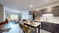 Located at 240 Thompson Ave E in West St. Paul, MN, this well-appointed 2-bedroom, 2-bathroom residence offers a thoughtfully designed single-floor layout with generous living space. The open-concept kitchen and living area serves as the heart of the home, where rich dark-stained cabinetry, white quartz countertops, a classic subway tile backsplash, and stainless steel appliances combine for a modern yet inviting aesthetic. A center island with bar seating provides a natural gathering spot. Light wood-style flooring flows throughout the main living areas, enhancing the bright, airy atmosphere created by large windows that invite abundant natural light. The living room offers a comfortable and versatile space with room for multiple seating arrangements. Both bedrooms are carpeted and feature windows with outdoor views; the primary bedroom includes its own spacious walk-in closet with wire shelving. The primary bathroom is finished with a dual-sink navy vanity, white countertops, and wood-look flooring. Three closets total provide excellent storage throughout. Additional conveniences include an in-unit laundry area and a dedicated utility room, rounding out this practical and stylish residence.