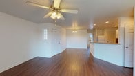 This single-floor residence on Upper Mount Vernon Road in Evansville, Indiana offers a thoughtfully designed layout with a blend of comfort and functionality. The open-concept living and dining area greets you at entry, showcasing rich, dark hardwood-style flooring and a ceiling fan with light fixture overhead. A decorative chandelier anchors the dining space, while recessed lighting carries through toward the kitchen. Natural light filters in through a sidelight window flanking the front door.

The kitchen is well-equipped with white cabinetry, light countertops, white appliances including an electric range, and a double sink. A peninsula counter connects the kitchen to the adjacent living area, enhancing the open flow. The living room extends to a sliding glass door that opens to a balcony, filling the space with natural light and outdoor views.

The bedrooms are carpeted for comfort, each featuring ceiling fans and generous closet space. One bedroom includes a walk-in closet and direct balcony access. Additional bedrooms offer ample windows, bringing in natural light. The bathroom is finished with hardwood-style flooring, a white vanity, and a tub-shower combination. A utility area houses an A.O. Smith ProMax water heater. The overall palette of white walls and neutral finishes creates a clean, bright ambiance throughout.
