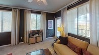 Located at 29675 N North Valley Pkwy in Phoenix, AZ, this single-floor residence offers a thoughtfully designed layout with a cohesive, contemporary aesthetic. The kitchen is equipped with dark espresso cabinetry, black appliances including a range, built-in microwave, and full-size refrigerator, complemented by light countertops and wood-look flooring that adds warmth to the space. Crown molding and natural light from a large window enhance the kitchen's clean, functional design.

The living area is spacious and inviting, featuring plush carpeting, crown molding, and multiple windows dressed with elegant drapes and blinds that allow for abundant natural light. A ceiling fan adds comfort, and the open layout provides ample room for relaxed living and entertaining.

The bedrooms are generously sized with soft carpeting, ceiling fans, and striking accent walls in bold terracotta tones that lend a vibrant character to each room. Mirrored sliding closet doors maximize the sense of space, and each bedroom offers convenient access to well-appointed bathrooms. The bathrooms feature dark vanity cabinetry, countertop sinks with large mirrors, tub-shower combinations, and wood-look flooring, creating a polished and practical finish throughout.