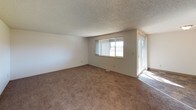Located at 69 Jadwin Avenue in Richland, Washington, this single-floor residence offers a practical and well-organized layout across several rooms. The living area is generously sized, featuring wall-to-wall carpeting, a textured ceiling, and large windows that admit natural light. A sliding glass door provides additional brightness and outdoor access. The galley-style kitchen is efficiently designed with dark wood cabinetry lining both sides, light countertops, tile flooring, and white appliances including a refrigerator and range, complemented by a double-basin stainless steel sink and a dishwasher. The unit includes multiple bedrooms, each finished with carpet flooring and textured ceilings. The bedrooms are served by natural light through individual windows that overlook the surrounding neighborhood. Two bathrooms serve the unit: a half bath featuring a vanity with dark wood cabinetry, a single sink, and a lighted mirror, and a full bath with a tub-shower combination, matching vanity, and tile flooring. A dedicated entryway connects smoothly to the main living space, offering a clear transition from the front door into the interior. Throughout, the neutral color palette and consistent finishes provide a clean, functional living environment.