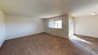 Located at 69 Jadwin Avenue in Richland, Washington, this single-floor residence offers a practical and well-organized layout across several rooms. The living area is generously sized, featuring wall-to-wall carpeting, a textured ceiling, and large windows that admit natural light. A sliding glass door provides additional brightness and outdoor access. The galley-style kitchen is efficiently designed with dark wood cabinetry lining both sides, light countertops, tile flooring, and white appliances including a refrigerator and range, complemented by a double-basin stainless steel sink and a dishwasher. The unit includes multiple bedrooms, each finished with carpet flooring and textured ceilings. The bedrooms are served by natural light through individual windows that overlook the surrounding neighborhood. Two bathrooms serve the unit: a half bath featuring a vanity with dark wood cabinetry, a single sink, and a lighted mirror, and a full bath with a tub-shower combination, matching vanity, and tile flooring. A dedicated entryway connects smoothly to the main living space, offering a clear transition from the front door into the interior. Throughout, the neutral color palette and consistent finishes provide a clean, functional living environment.