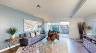 Located in San Diego, CA 92110, this two-story residence offers three bedrooms and two bathrooms across a well-utilized floor plan. The ground floor welcomes you into a bright, inviting living room featuring a bold teal accent wall, wood-look flooring, and a sliding glass door that opens directly onto a private, fenced patio — perfect for enjoying the Southern California sunshine. The adjacent kitchen is outfitted with white cabinetry, a gas range, full-size appliances, and light tile flooring, with a window that brings in natural daylight. A combined kitchen and living area on this floor makes for easy entertaining. Upstairs, the spacious primary bedroom features a vaulted wood-plank ceiling, plush carpet, generous closet space, and windows that fill the room with natural light. Additional bedrooms offer comfortable proportions and ample storage. The two bathrooms are clean and functional — one featuring a white vanity and mirrored medicine cabinet, the other with hardwood flooring, a white vanity with drawers, and a tub/shower combination. A versatile bonus room on the upper level provides flexible living space. The private patio, framed by a gated wood fence, offers views of swaying palms and a quintessential San Diego sky.