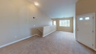 Located at 825 Summer Place Ln in Mishawaka, Indiana, this single-floor residence offers a practical and comfortable layout designed for everyday living. The open living area is highlighted by vaulted ceilings that lend a sense of spaciousness and airiness, with natural light streaming in through large windows fitted with vertical blinds. The space transitions smoothly into a functional kitchen, which features warm-toned wood cabinetry, a white refrigerator, electric range, and a double sink set into a countertop peninsula. A walk-in pantry with wire shelving provides generous storage directly off the kitchen. The neutral-toned bedrooms are finished with plush carpeting and windows that bring in natural light and outdoor greenery views, creating a calm and restful atmosphere. Each room is finished with white panel doors and clean white baseboards throughout. The bathroom includes a wood-vanity with sink, toilet, and tile flooring. A dedicated laundry area accommodates a full-sized washer and dryer with an overhead wire shelf, adding practical convenience. Throughout the home, warm beige walls and consistent finishes create a cohesive, move-in-ready environment suited for comfortable residential living.