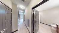 Located at 401 Williams Ave SW in Huntsville, Alabama, this single-floor unit offers a thoughtfully designed layout with modern finishes throughout. The hallways are bright and well-lit, featuring flush-mount ceiling lights, light wood-style flooring, dark five-panel doors with brushed hardware, and neutral gray walls that create a clean, contemporary feel.

The kitchen is a standout feature, equipped with rich warm-toned wood cabinetry, granite countertops, and a full suite of stainless steel appliances including a refrigerator, range, microwave, and dishwasher. A subway tile backsplash adds a polished finishing touch, while track lighting overhead ensures the space is well-illuminated.

The bedroom is generously proportioned, with light flooring, neutral walls, and a ceiling fan with integrated lighting. The room benefits from a high ceiling line that lends an open, airy quality to the space.

The bathroom is finished to a high standard, featuring granite countertops atop warm wood vanity cabinetry, an undermount sink, a framed walk-in shower with glass sliding doors, and light tile flooring. A large mirror and modern fixtures round out the clean, functional design.

Overall, this unit presents a cohesive modern aesthetic with quality finishes and a practical, comfortable layout suited for everyday living.