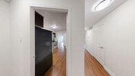 Located at 675 Richmond St in downtown London, Ontario, this well-appointed 3-bedroom, 2-bathroom unit offers a thoughtfully designed single-floor layout with generous living space. Rich hardwood flooring flows throughout the main living areas and bedrooms, complementing the clean white walls and textured ceilings that give each room a bright, airy feel.

The living area is a standout, featuring elegant French doors that open to windows overlooking city views, allowing natural light to fill the space. The kitchen is equipped with dark espresso cabinetry, stainless steel appliances including a range, microwave, and dishwasher, light stone countertops, and a classic subway tile backsplash — a functional and stylish space for everyday use.

The three bedrooms are well-proportioned, with the generously sized primary bedroom offering ample room for furnishings. Bedrooms feature six-panel doors and sliding closets for practical storage. The two bathrooms are finished with warm beige tile work — one offering a glass-enclosed standing shower with a wood-toned vanity, and the other a full soaker tub with a curved shower rod. A utility room and hallway round out the practical layout of this comfortable urban residence.