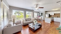 Located at 401 W Seminole Blvd in Sanford, Florida, this 2-bedroom, 2-bathroom residence offers a thoughtfully designed single-floor layout that maximizes both comfort and functionality. The open-concept living and dining area is bathed in natural light from large windows overlooking lush greenery, and features rich wood-style flooring, a ceiling fan, and a seamless flow into the kitchen and dining space.

The kitchen is a standout feature, showcasing granite countertops, white cabinetry, a tile backsplash, a central island, and a full suite of stainless steel appliances. A dedicated dining area sits adjacent, framed by bright windows that bring the outdoors in.

Both bedrooms are carpeted and equipped with ceiling fans. The primary bedroom offers a comfortable, well-proportioned retreat, while the second bedroom provides equally inviting accommodations. Each room benefits from dedicated closet space.

The two full bathrooms each include a tub/shower combination with a vanity featuring granite countertops and wood-style flooring. A hallway connects the bedrooms and bathrooms, providing a clear and efficient layout throughout. The neutral gray tones and consistent finishes across the home create a cohesive, modern aesthetic.