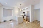 Located at 1790 Keene Cres SW in Edmonton, Alberta, this well-designed two-bedroom, two-bathroom unit offers a clean, contemporary aesthetic across a single level. Light-toned hardwood flooring runs throughout, complementing the crisp white walls and recessed lighting that give the space a bright, open feel.

The kitchen is a standout feature, equipped with stainless steel appliances including a range, microwave, and refrigerator. White shaker-style cabinetry extends to the upper walls, while a spacious quartz countertop with an undermount sink and modern pendant lighting adds a polished, functional touch.

Both bedrooms are well-proportioned and filled with natural light through large windows with roller blinds. Baseboard heating is present throughout. The primary bedroom includes a dedicated closet with built-in shelving, while the hallways provide additional storage via a double-door closet.

The two bathrooms are finished with large-format grey marble-style tile and glass enclosures. One features a soaker tub with a full glass panel and a handheld shower, while the other offers a glass-enclosed walk-in shower — both exuding a refined, spa-like quality. The overall layout is efficient and thoughtfully organized, making excellent use of the available space.