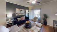 This single-floor residence offers a thoughtfully designed layout with multiple living areas, bedrooms, and bathrooms, each finished with consistent, contemporary detailing. The living room serves as the central gathering space, featuring wood-style flooring, crown molding, a ceiling fan, and a large sliding glass door that opens to a private balcony, allowing natural light to fill the room. A bold accent wall adds depth and character to the space.

The kitchen is well-equipped with dark granite countertops, light wood cabinetry, stainless steel appliances including a range and over-the-range microwave, and under-cabinet lighting that creates a warm ambiance during meal preparation.

The bedrooms each offer a comfortable retreat, with plush carpeting, ceiling fans, natural light from well-placed windows, and bold accent walls. The primary bedroom includes a walk-in closet with built-in shelving for ample storage.

Both bathrooms are finished with dark granite countertops, undermount sinks, light wood vanity cabinetry, and large mirrors with overhead lighting. Each bathroom features a shower-tub combination with tile surround and curtained enclosures, complemented by wood-style flooring throughout.