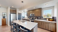 Located at 125 S Navajo St in Salt Lake City, UT, this contemporary three-story townhome offers a well-organized layout spread across three distinct levels. The ground floor houses an attached garage with direct interior access, utility areas, and an entry that connects seamlessly to the upper floors via staircase.

The main living level serves as the heart of the home, featuring an open-concept dining room, kitchen, and living room. The kitchen is outfitted with warm wood-toned cabinetry, a bold slate tile backsplash, stainless steel appliances, and a large white quartz island with bar seating — all illuminated by modern pendant lighting. The living area is bright and airy, with recessed lighting and large windows dressed in sheer curtains that invite natural light. A pantry and dedicated laundry room round out this floor's functionality.

The upper level is home to two bedrooms, including a generously sized primary bedroom with plush carpeting, natural light from multiple windows, and access to a well-appointed en-suite bathroom. Five closets throughout the home provide abundant storage. A private balcony, office, and hallway complete the upper floor.

With clean lines, modern finishes, and a thoughtful three-floor plan, this townhome delivers a polished, contemporary living experience in an attractively landscaped community setting.